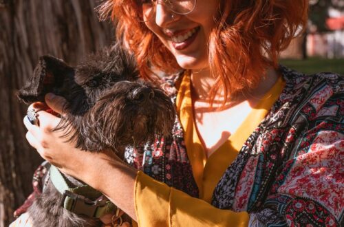 woman smiling while looking at her dog